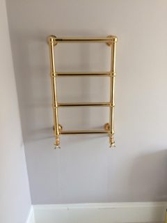 Install of gold plated towel rail in new bathroom